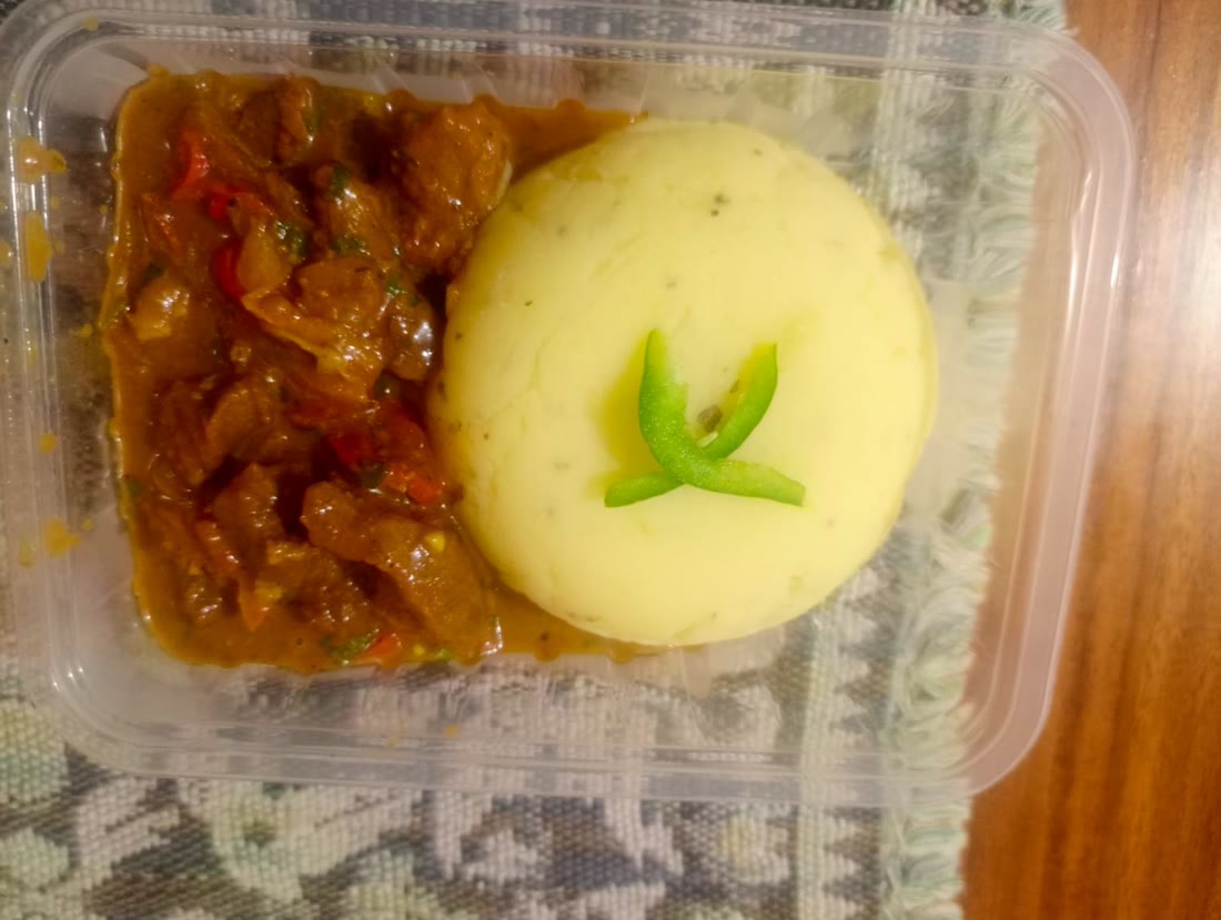 Beef stew and mashed potato in a takeaway box